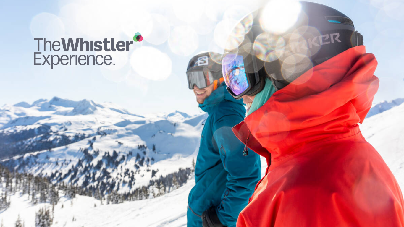 Skier riding down mountain on a sunny day blue skies and fresh powder kicking up behind